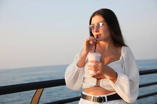海の近くでおいしいミルクシェイクを持つ美しい女性 テキストのためのスペース — ストック写真