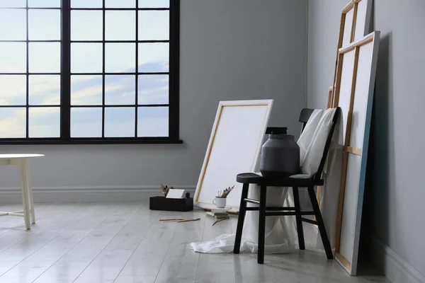 Stylish artist\'s studio interior with canvas and brushes