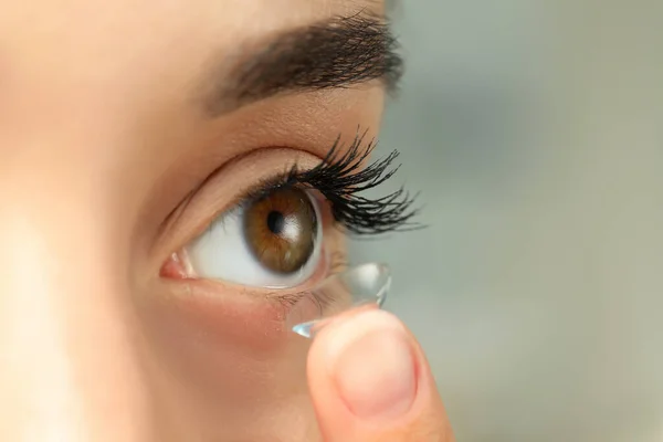 Woman Putting Contact Lens Her Eye Blurred Background Closeup — 스톡 사진