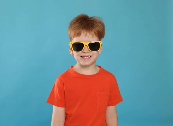 Netter Kleiner Junge Mit Sonnenbrille Auf Hellblauem Hintergrund — Stockfoto