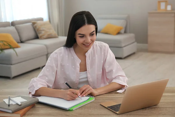 Jonge Vrouw Neemt Aantekeningen Tijdens Online Webinar Aan Tafel Binnen — Stockfoto