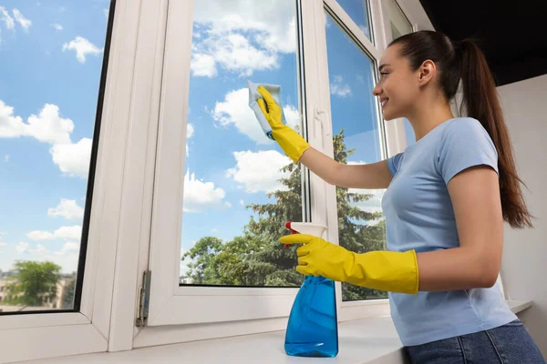 Gelukkig Jong Vrouw Schoonmaken Raam Glas Met Doek Spray Binnen — Stockfoto