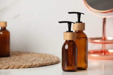 Kutu kapaklı şişeler beyaz masada, yakın plan. Metin için boşluk