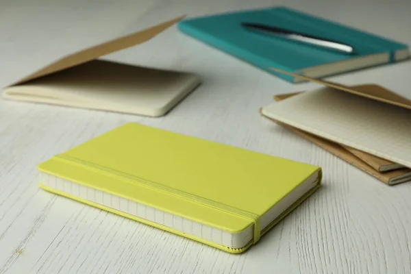 Yellow planner and notebooks on white wooden table