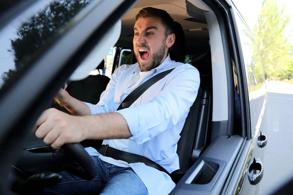 車の中で感情的な男 積極的な運転行動 — ストック写真