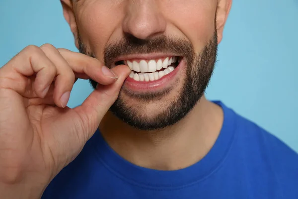 Homem Mordendo Unhas Fundo Azul Claro Close — Fotografia de Stock