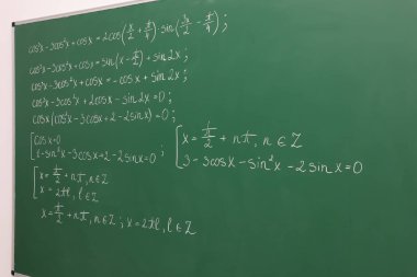 Yeşil karatahtaya yazılmış birçok farklı matematik formülü