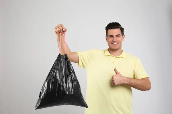 Homem Segurando Saco Lixo Completo Fundo Claro — Fotografia de Stock