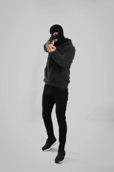 Homme Portant Une Cagoule Noire Avec Pistolet Sur Fond Gris — Photo