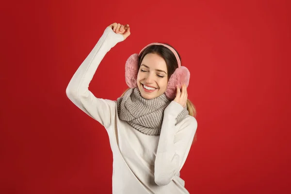 Ευτυχισμένη Γυναίκα Που Φοράει Ζεστά Ακουστικά Κόκκινο Φόντο — Φωτογραφία Αρχείου