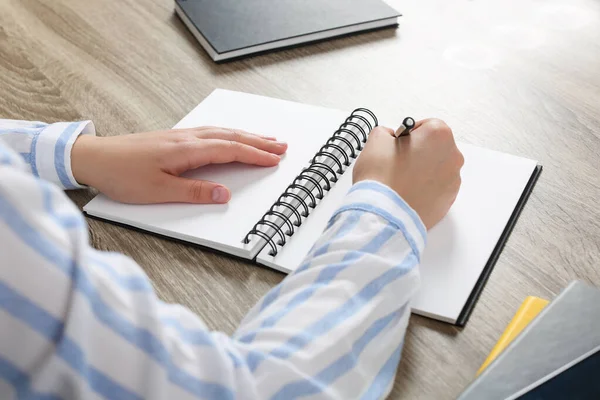 Schrijvende Vrouw Notitieboekje Aan Houten Tafel Close — Stockfoto