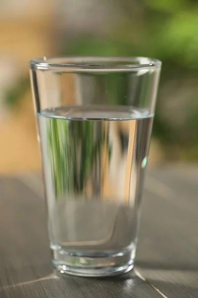 Glas Zuiver Water Houten Tafel Tegen Wazige Ondergrond Close — Stockfoto