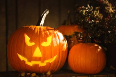 Karanlıktaki ahşap bankta duran korkunç balkabağı Jack O 'Lantern. Cadılar Bayramı Dekorasyonu