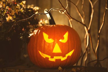 Karanlıktaki ahşap bankta duran korkunç balkabağı Jack O 'Lantern. Cadılar Bayramı Dekorasyonu