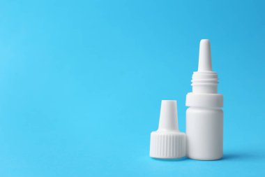 Açık mavi arka planda bir şişe tıbbi damla. Metin için boşluk