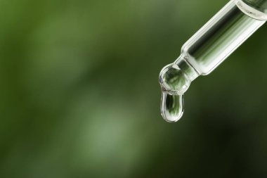 Pipetten damlayan tıbbi ürün bulanık arka planda, yakın planda. Metin için boşluk