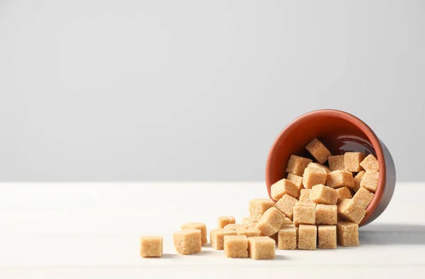 Bol Renversé Avec Cubes Sucre Brun Sur Table Bois Blanc — Photo