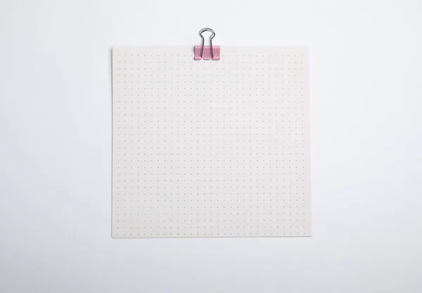 Sheet of paper with clip on white background, top view