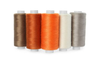 Beyaz arkaplanda farklı renklerde dikiş iplikleri