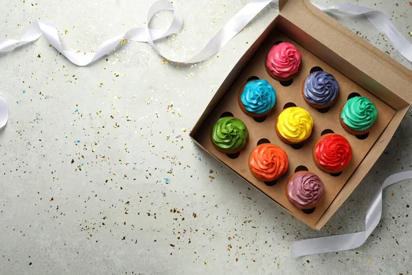 Caixa Com Deliciosos Cupcakes Coloridos Fita Confete Mesa Cinza Claro — Fotografia de Stock