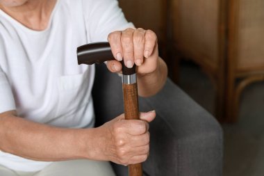 Elderly woman with walking cane indoors, closeup. Home care service