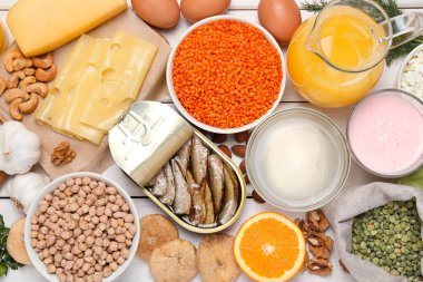 Set of natural food high in calcium on white wooden table, flat lay