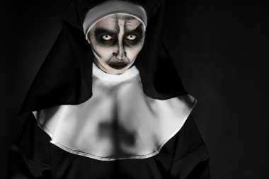 Siyah arka planda korkunç bir rahibenin portresi, mesaj için boşluk. Cadılar Bayramı partisi görünüşü