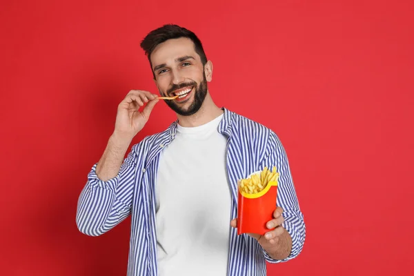 Man Eating French Fries Red Background — ストック写真