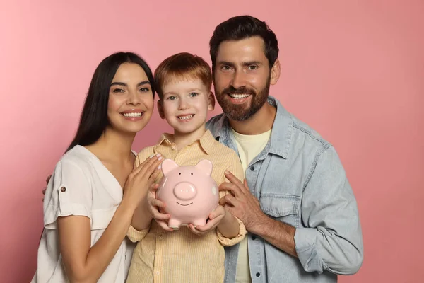 Familia Feliz Con Alcancía Cerámica Sobre Fondo Rosa Pálido — Foto de Stock