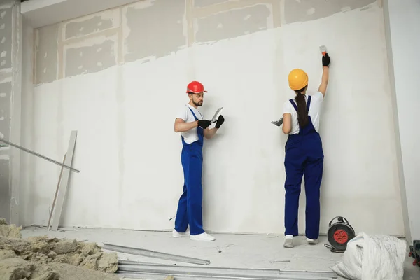 Trabajadores Profesionales Yeso Pared Con Cuchillos Masilla Sombreros Duros Interiores — Foto de Stock
