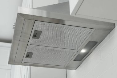 Mutfaktaki beyaz tuğlalı duvara modern kaput.
