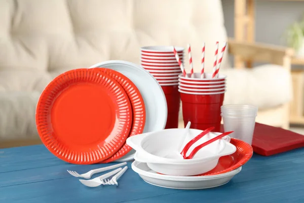 Disposable tableware on blue wooden table indoors