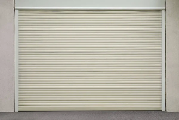 Building with white roller shutter garage door