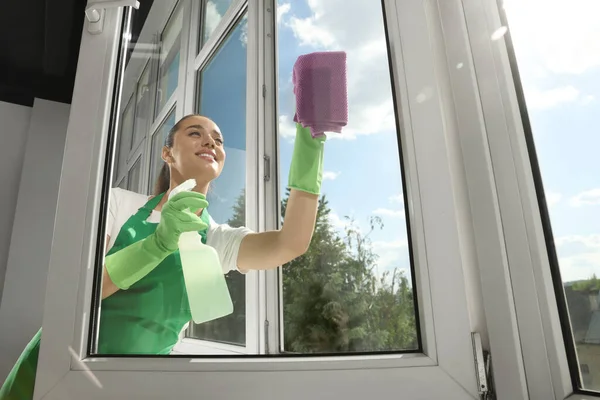 Gelukkig Jong Vrouw Schoonmaken Raam Glas Met Doek Spray Binnen — Stockfoto