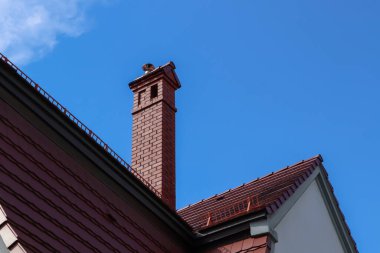 Mavi gökyüzüne karşı kahverengi çatılı güzel bir ev