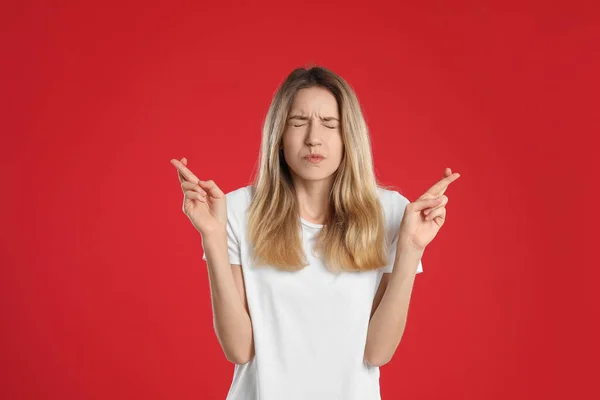 Mulher Com Dedos Cruzados Fundo Vermelho Conceito Superstição — Fotografia de Stock