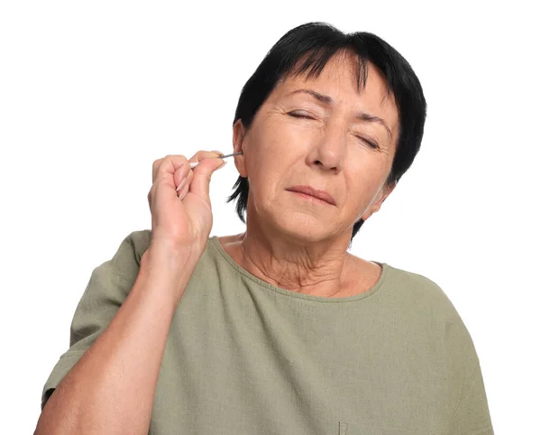 老年妇女用白色背景的棉签擦拭耳朵 — 图库照片