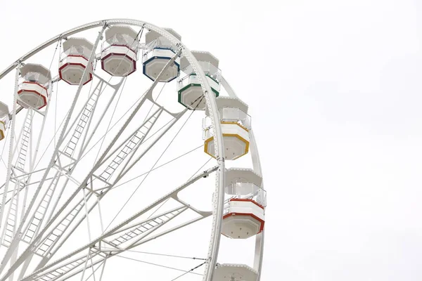 Large white observation wheel against sky, space for text