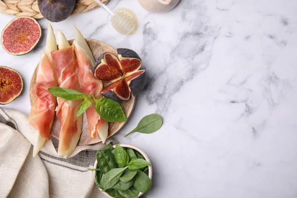 Lezzetli kavun, jambon ve incir beyaz mermer masada servis edilir. Metin için boşluk