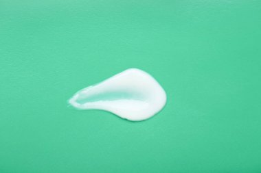 Açık yeşil arka planda vücut kremi örneği, üst manzara. Kozmetik ürünü