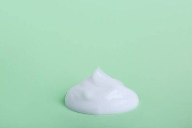 Açık yeşil arka planda vücut kremi örneği
