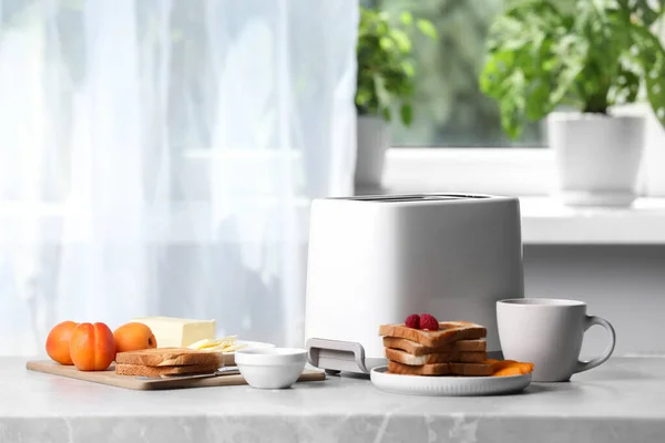 Toaster, roasted bread and coffee on light gray marble table, space for text. Tasty breakfast