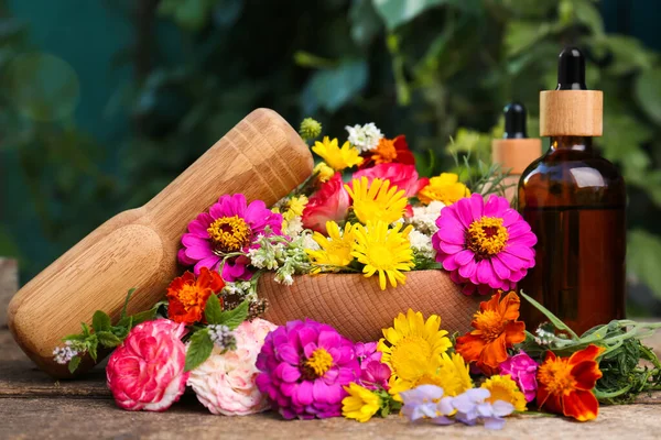 Botellas Con Aceite Esencial Mortero Mortero Diferentes Flores Mesa Madera —  Fotos de Stock