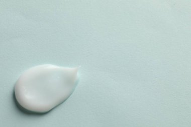 Açık mavi arka planda yüz kremi örneği, üst manzara. Metin için boşluk