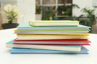 İçerideki beyaz ahşap masada renkli planlamacılar yığını.