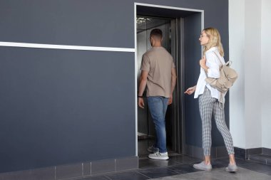 Genç bir çift modern asansöre biniyor.