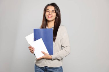 Açık gri arka plan kitapları olan mutlu genç öğretmen. Metin için boşluk