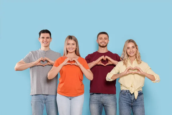 Felices Voluntarios Haciendo Corazones Con Sus Manos Sobre Fondo Azul —  Fotos de Stock