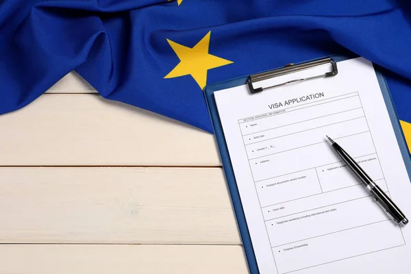 Visa application form, pen and flag of European Union on white wooden table, flat lay. Space for text