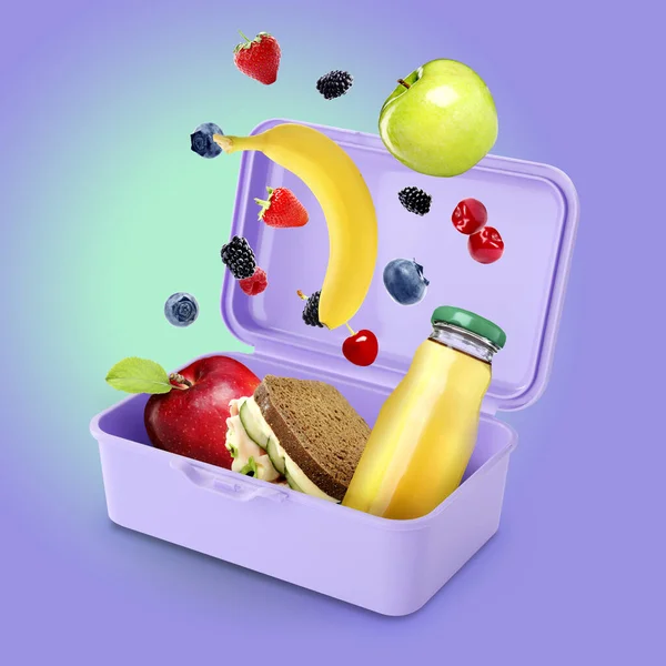 Different fresh food falling into lunch box on color background. School meal